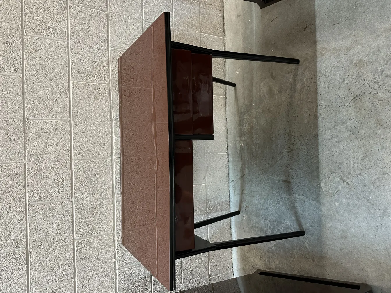 Antique desk with two drawers in a simple setting.