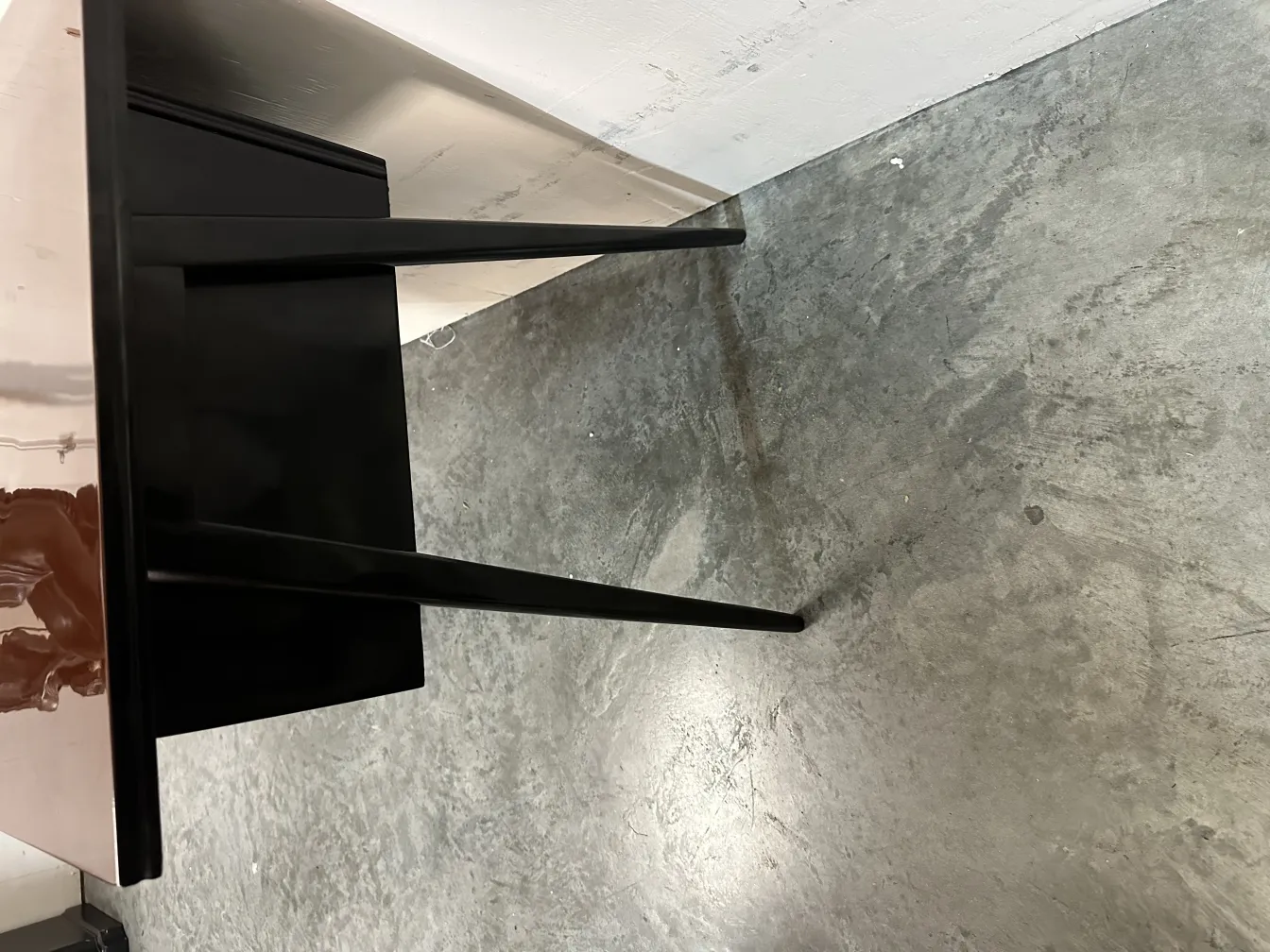 escritorio antigo com pernas finas em piso cinza