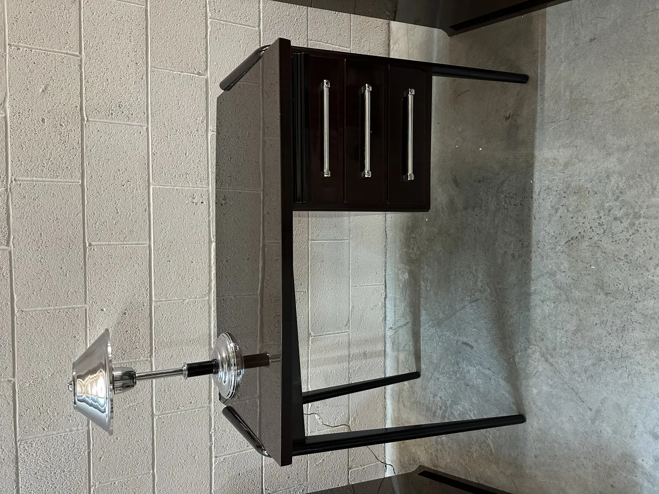 Vista de um escritório antigo com três gavetas e uma lâmpada