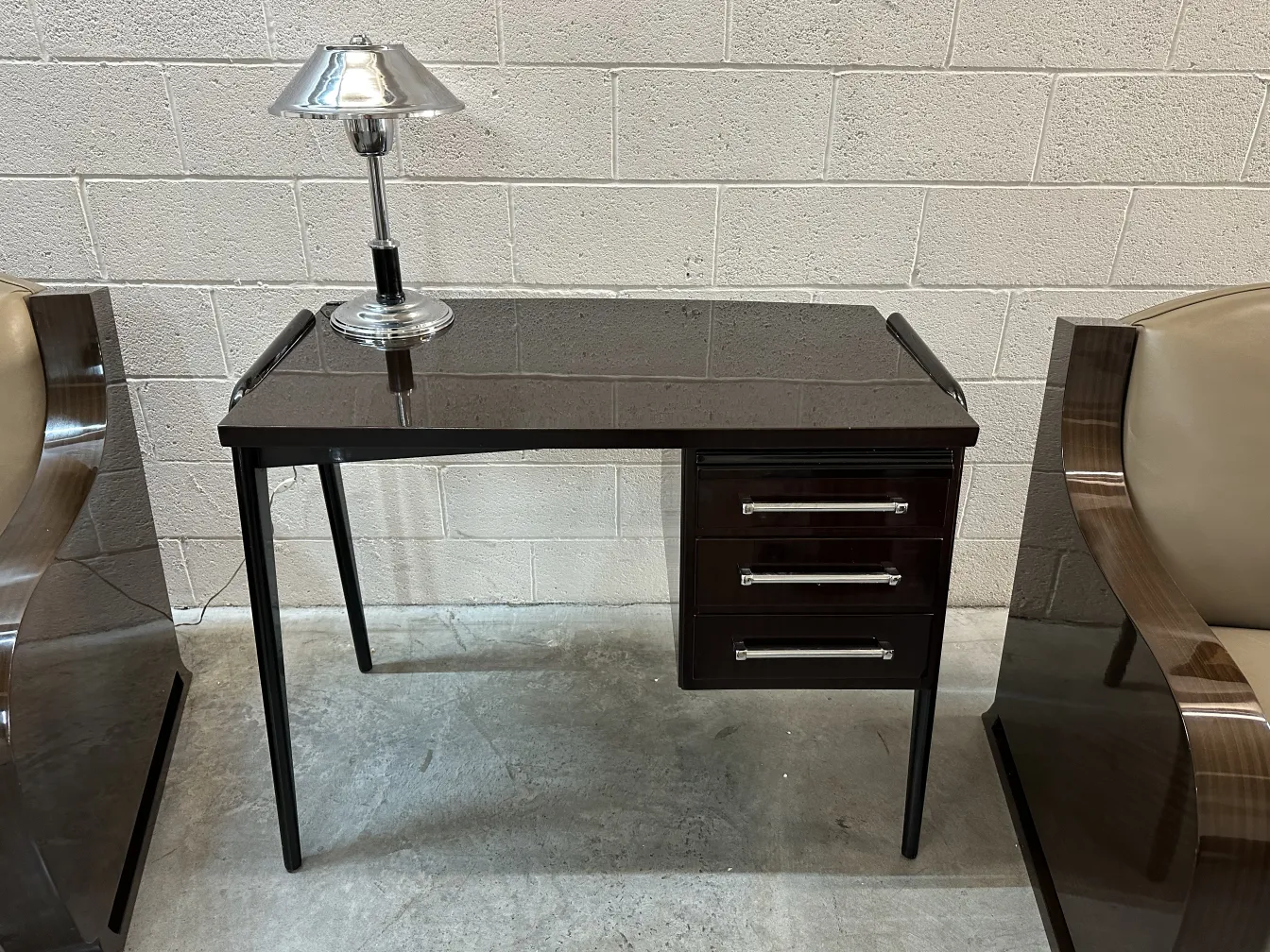 Antique dark desk with classic lamp on top.