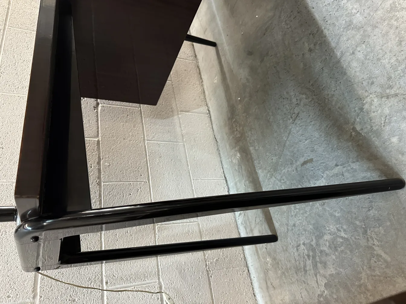 Vue latérale d'un bureau ancien avec un design minimaliste, exposé dans un cadre simple.