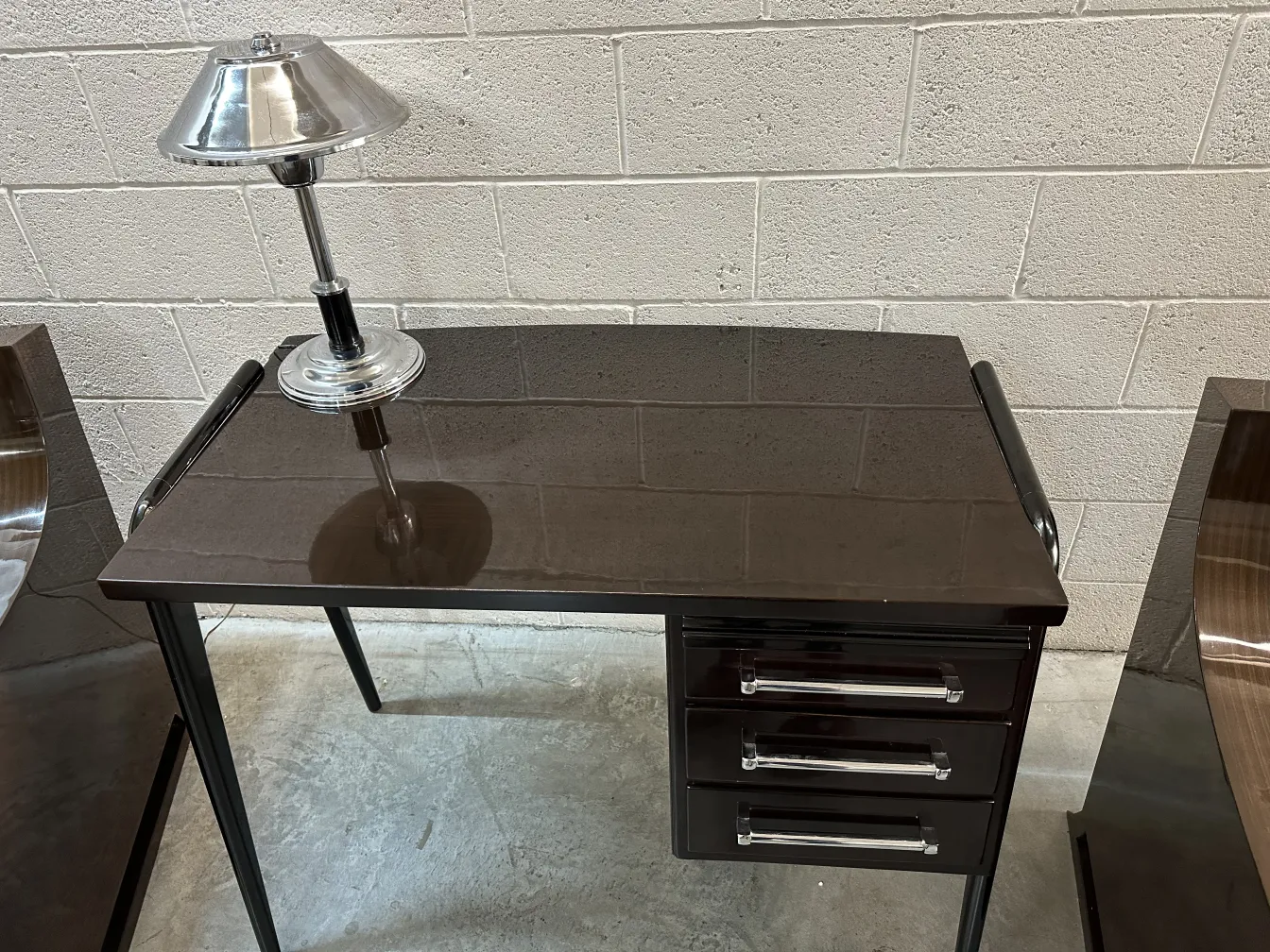 antique desk with glossy finish and silver lamp