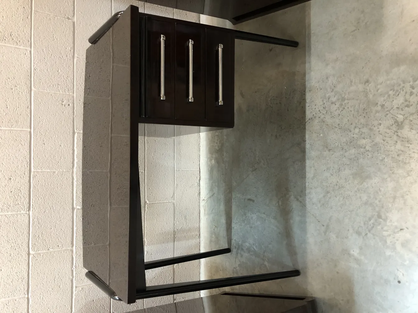 antique desk with three drawers in a neutral setting