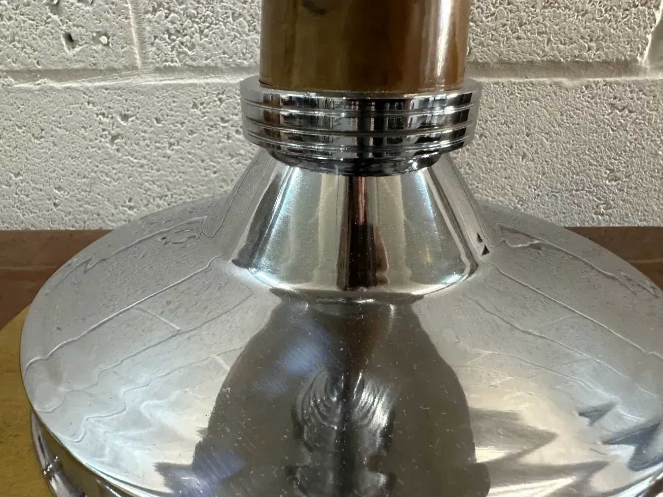 Vue rapprochée de 2 lampes de table anciennes avec une base brillante et des détails métalliques.