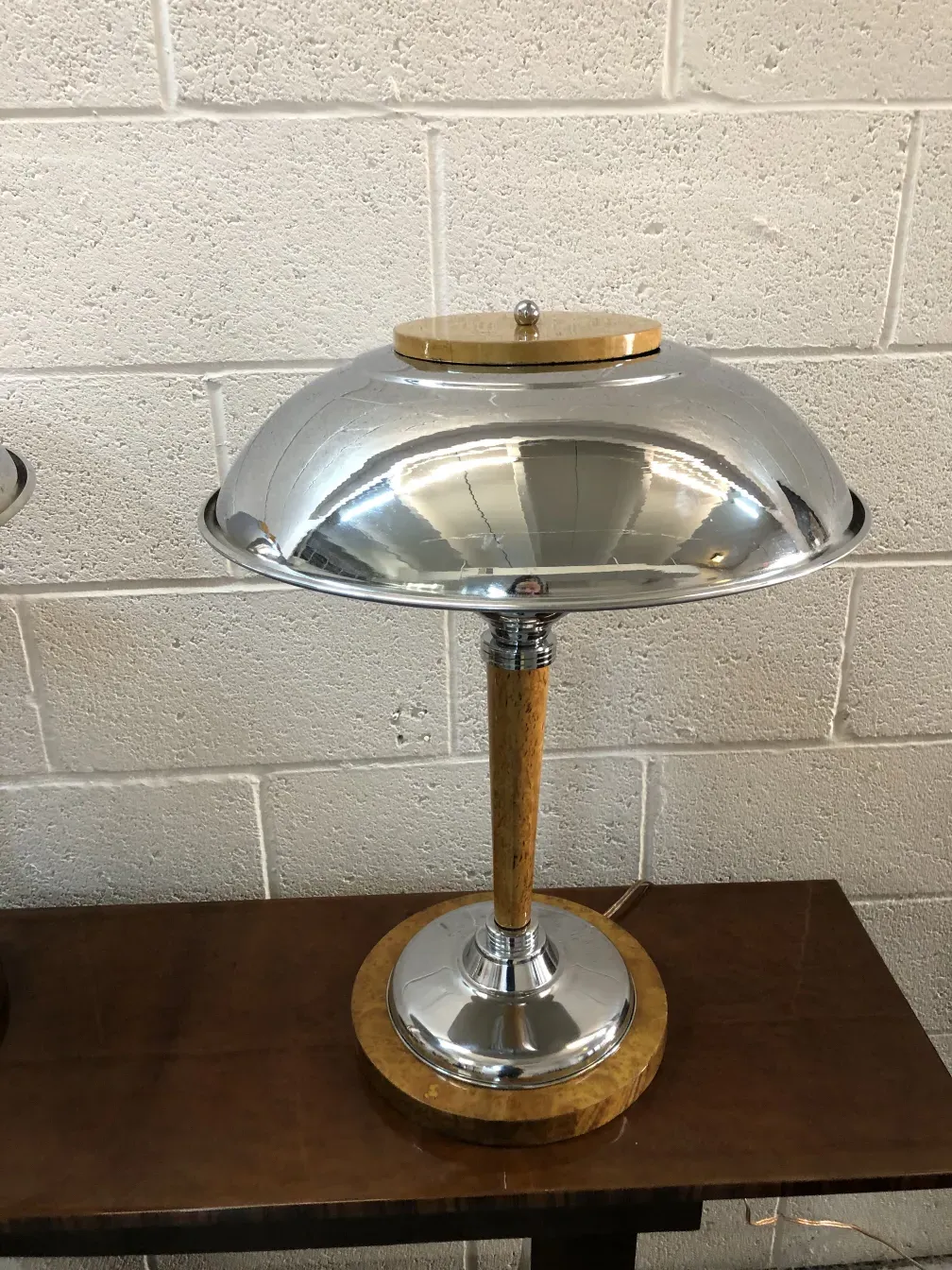 Dos lámparas de mesa antiguas con base redonda y diseño elegante, sobre una superficie de madera.