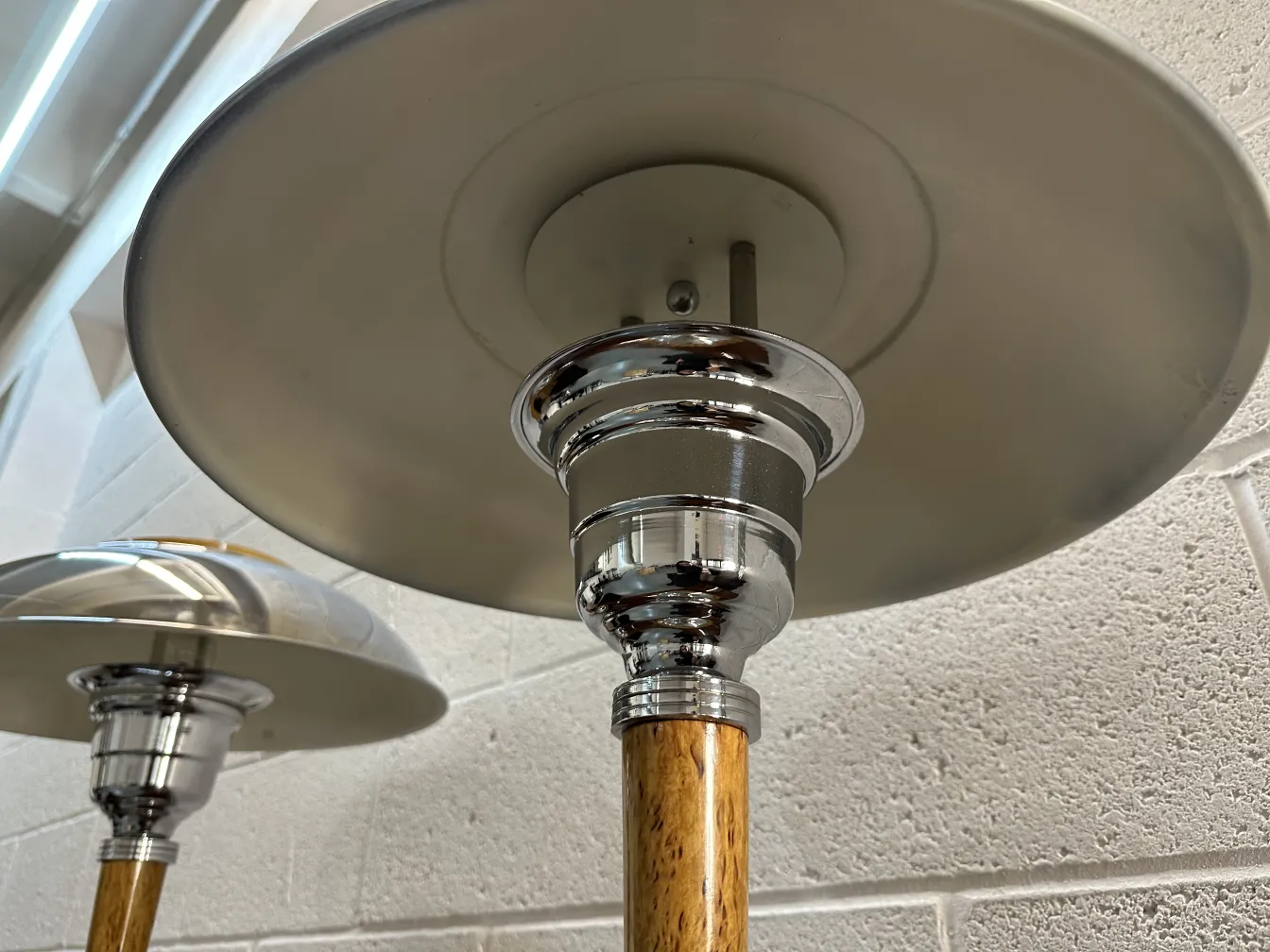 Due lampade da tavolo antiche con base in legno e chiaro d'argento, in un ambiente accogliente.