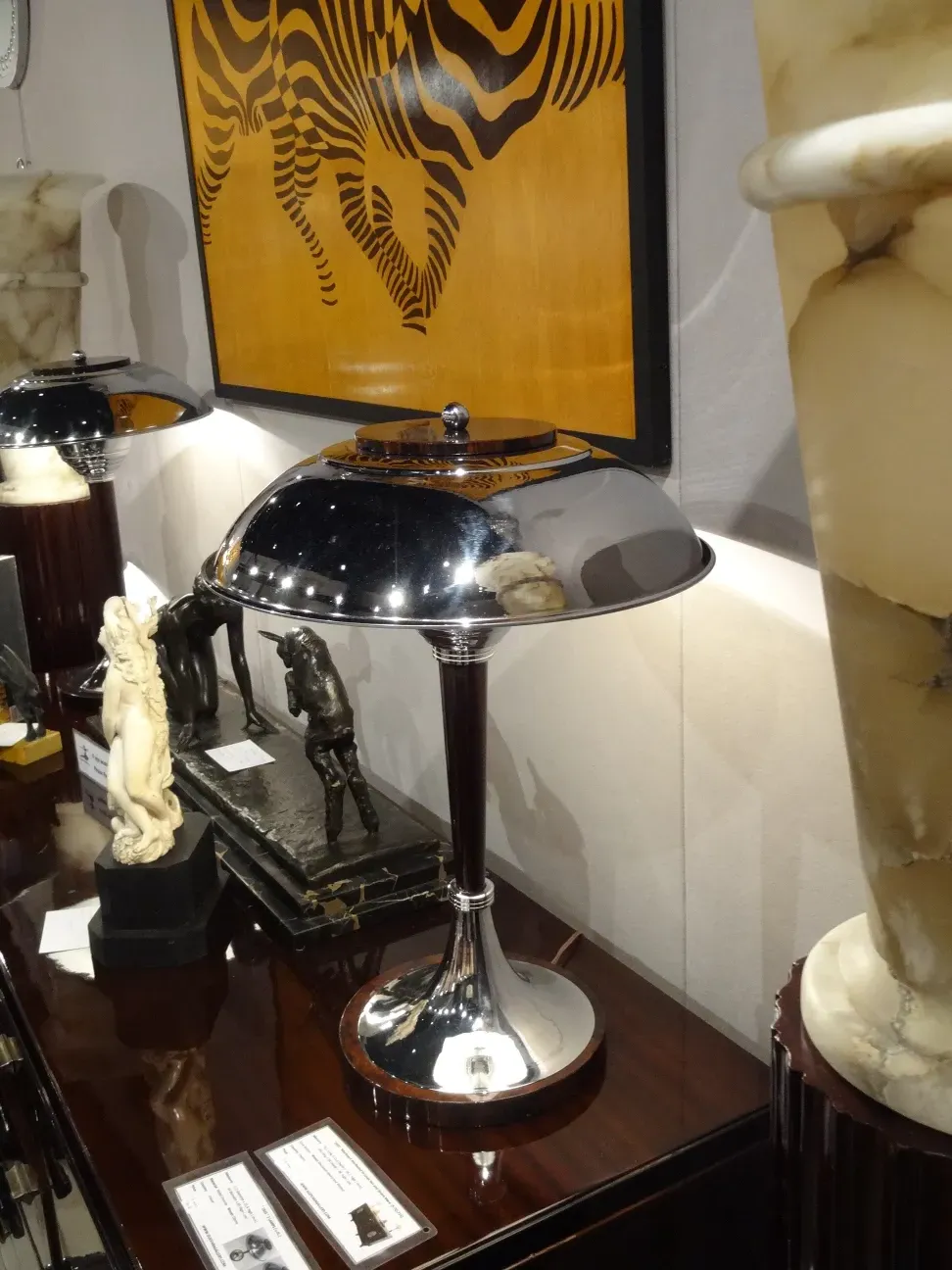 duas lampadas de mesa antigas com bases elegantes e detalhes artísticos, cercadas por decoração