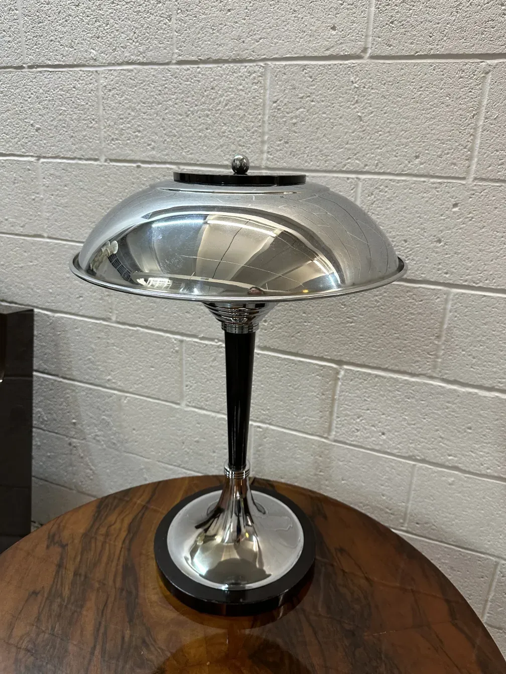 Zwei antike Tischleuchten mit elegantem Design, eine metallisch und glänzend, in einer gemütlichen Umgebung.