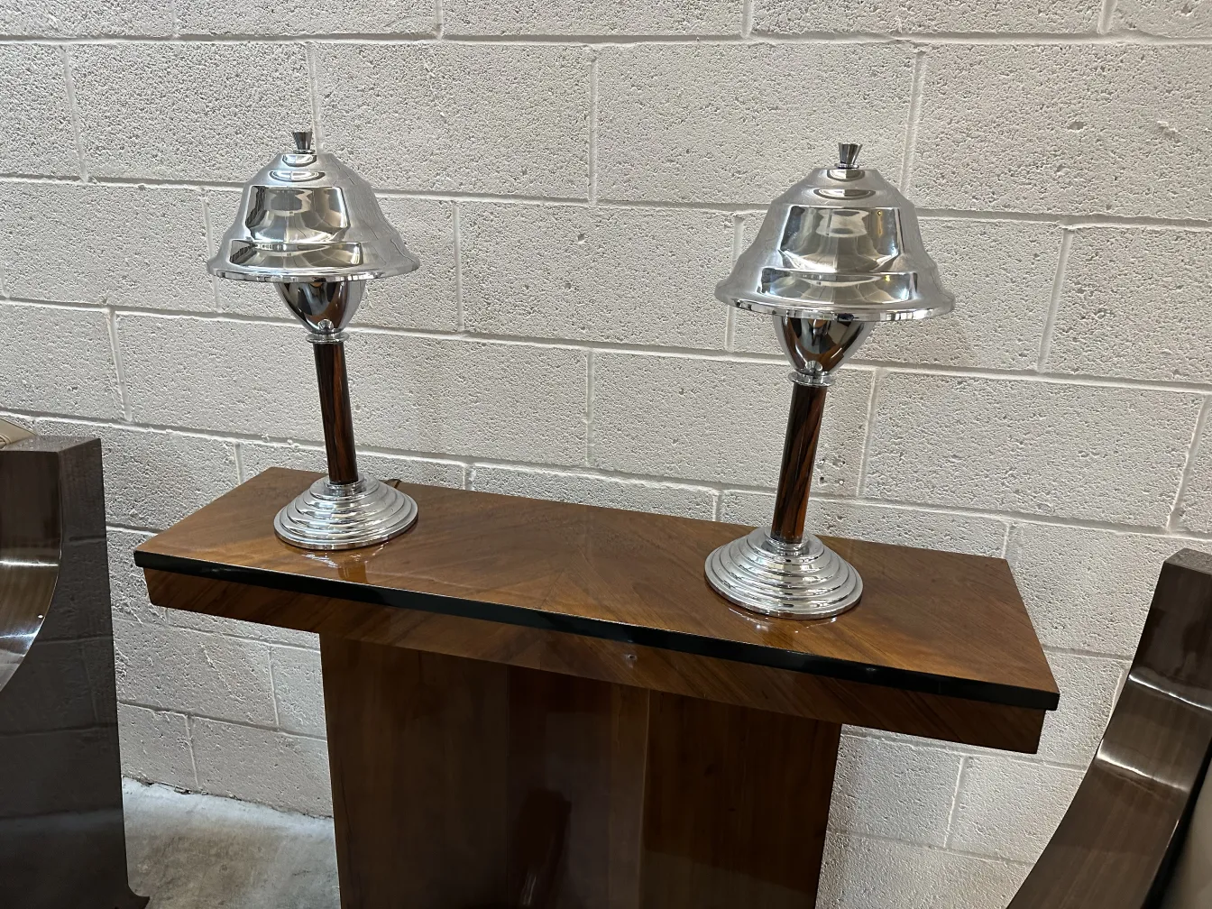 side view of two antique table lamps with shiny bases and metal shades.