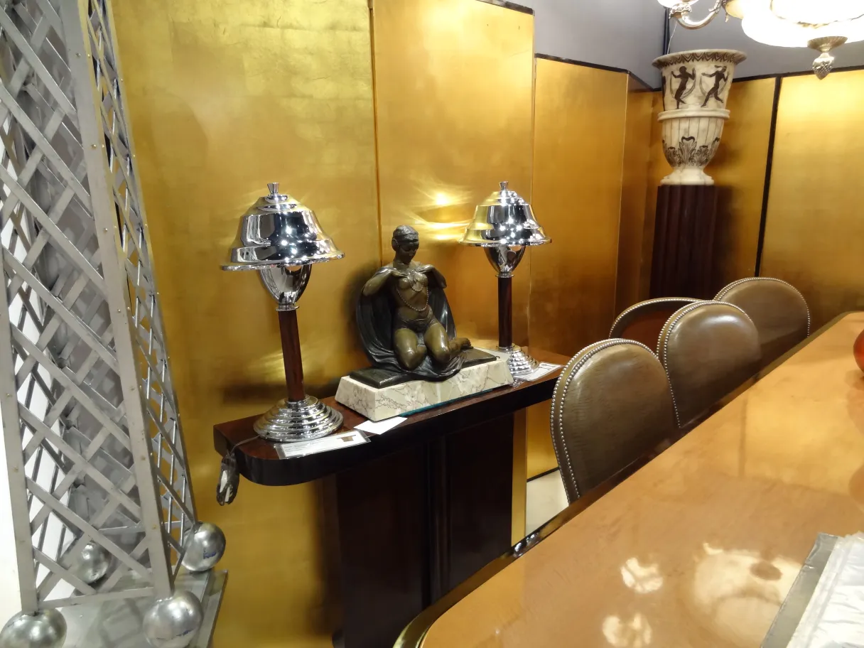 due lampade da tavolo antiche accanto a una figura decorativa in un ambiente elegante