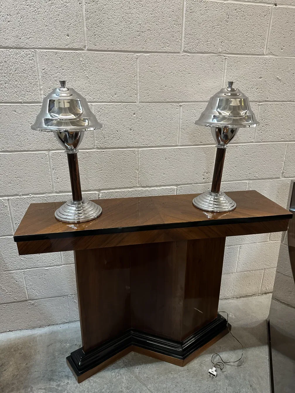Set of 2 antique table lamps on a dark table.