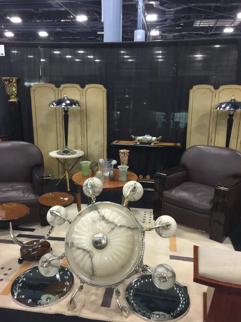 dos lámparas de mesa antiguas con bases ornamentadas y pantallas decorativas, rodeadas de muebles retro