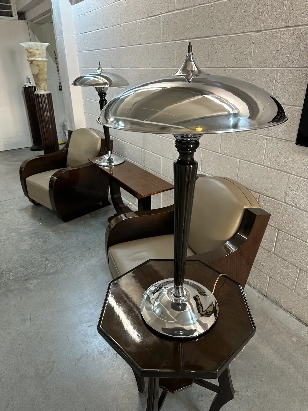 Duas lampadas de mesa antigas com bases elegantes e cúpulas brilhantes, em um ambiente com móveis sofisticados.