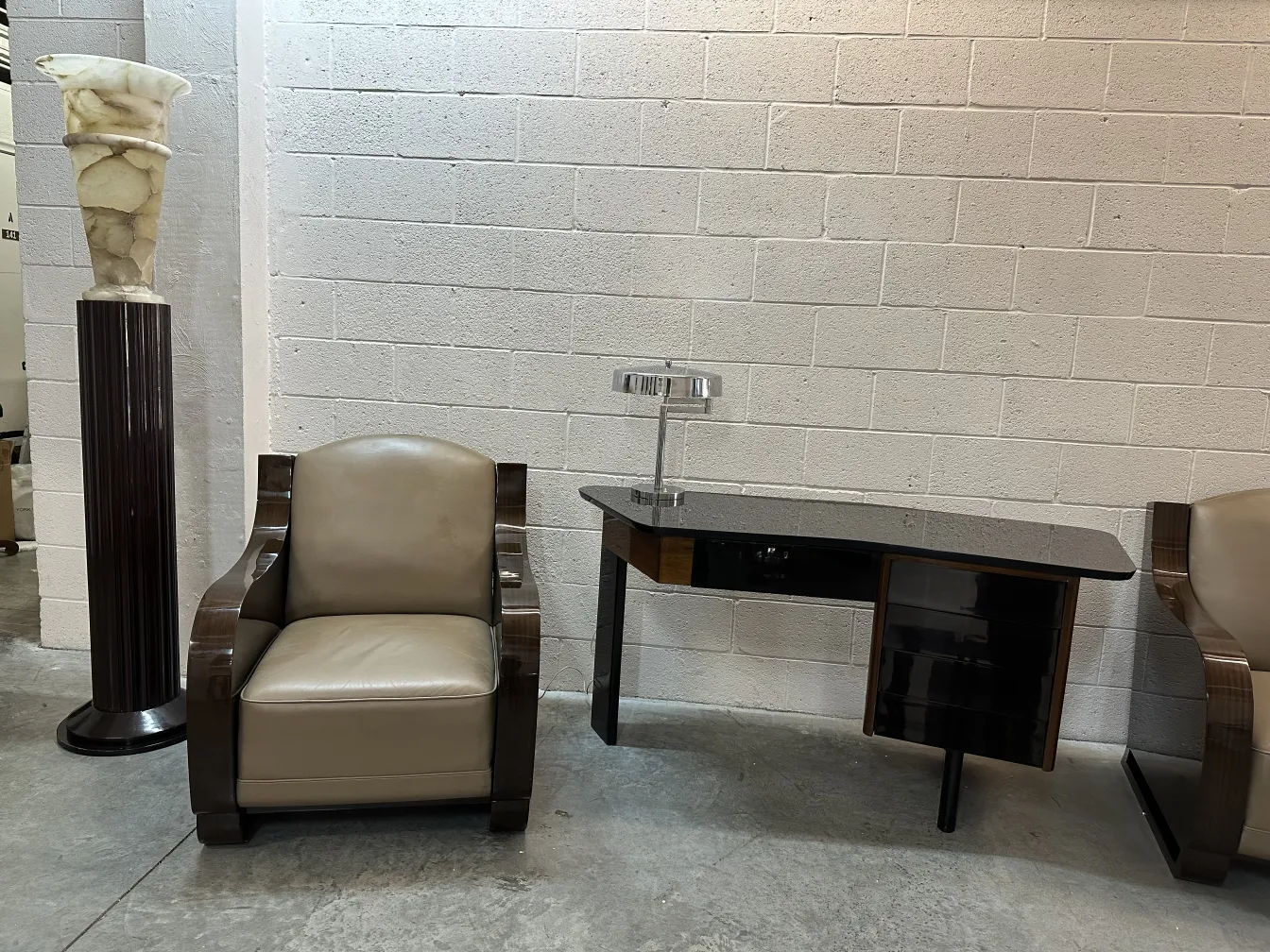 Antica lampada da tavolo con design elegante accanto a una poltrona.