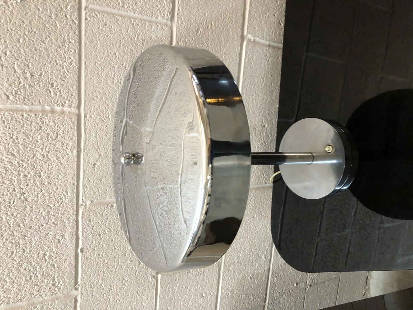 Lampada da tavolo antica con base lucida e design elegante, su sfondo neutro.