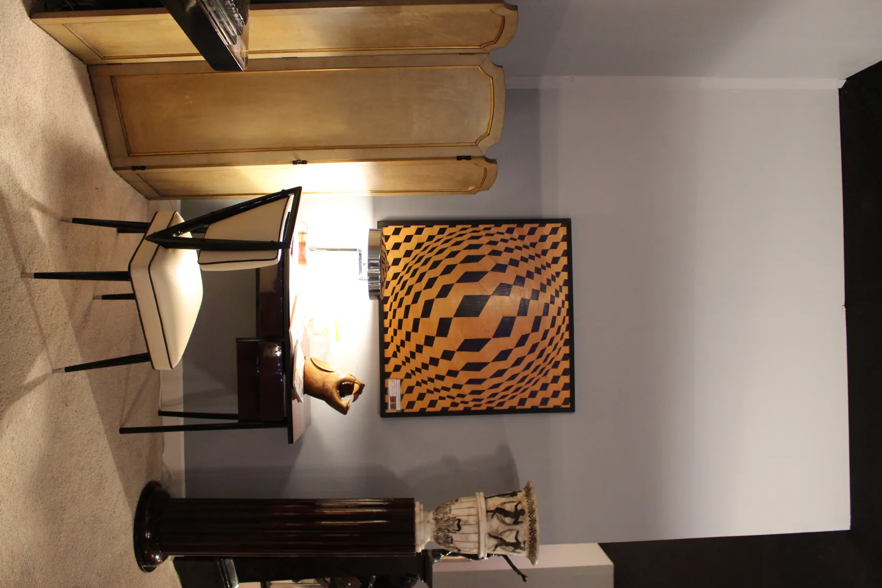 Antica lampada da tavolo che illumina un ambiente accogliente, su una scrivania con una sedia bianca.