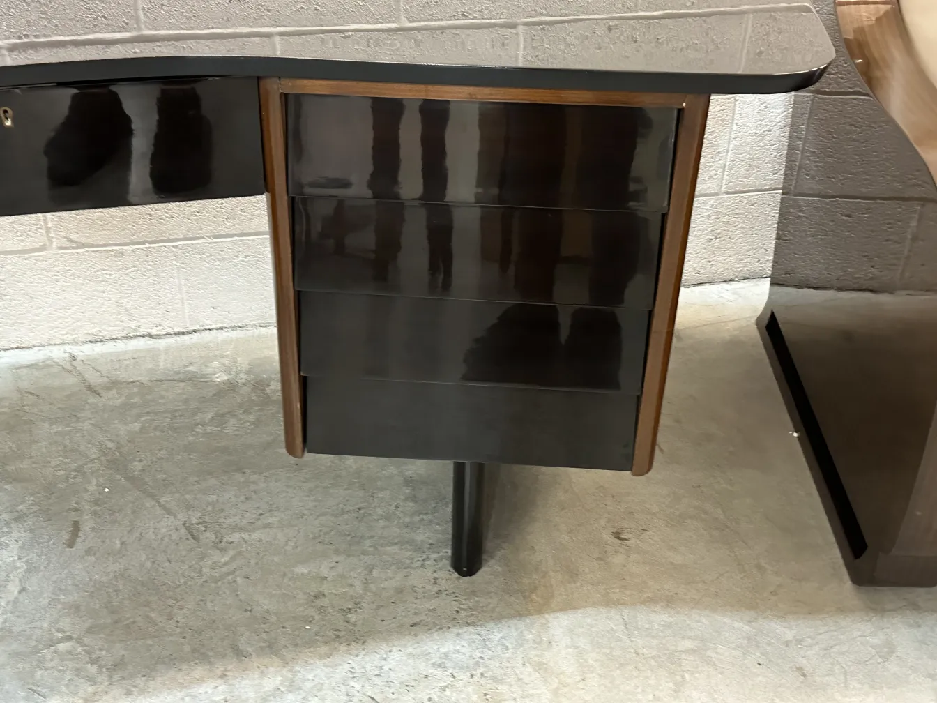 luminária de mesa antiga com base de cores escuras e detalhes polidos, em um ambiente moderno