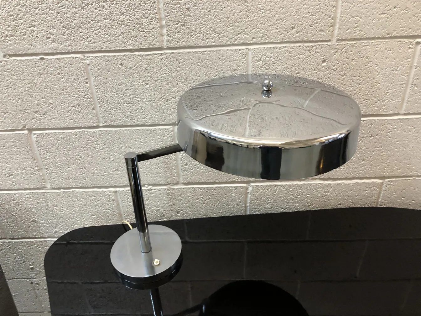 Lampada da tavolo antica con base rotonda, elegante e funzionale in un ambiente moderno.