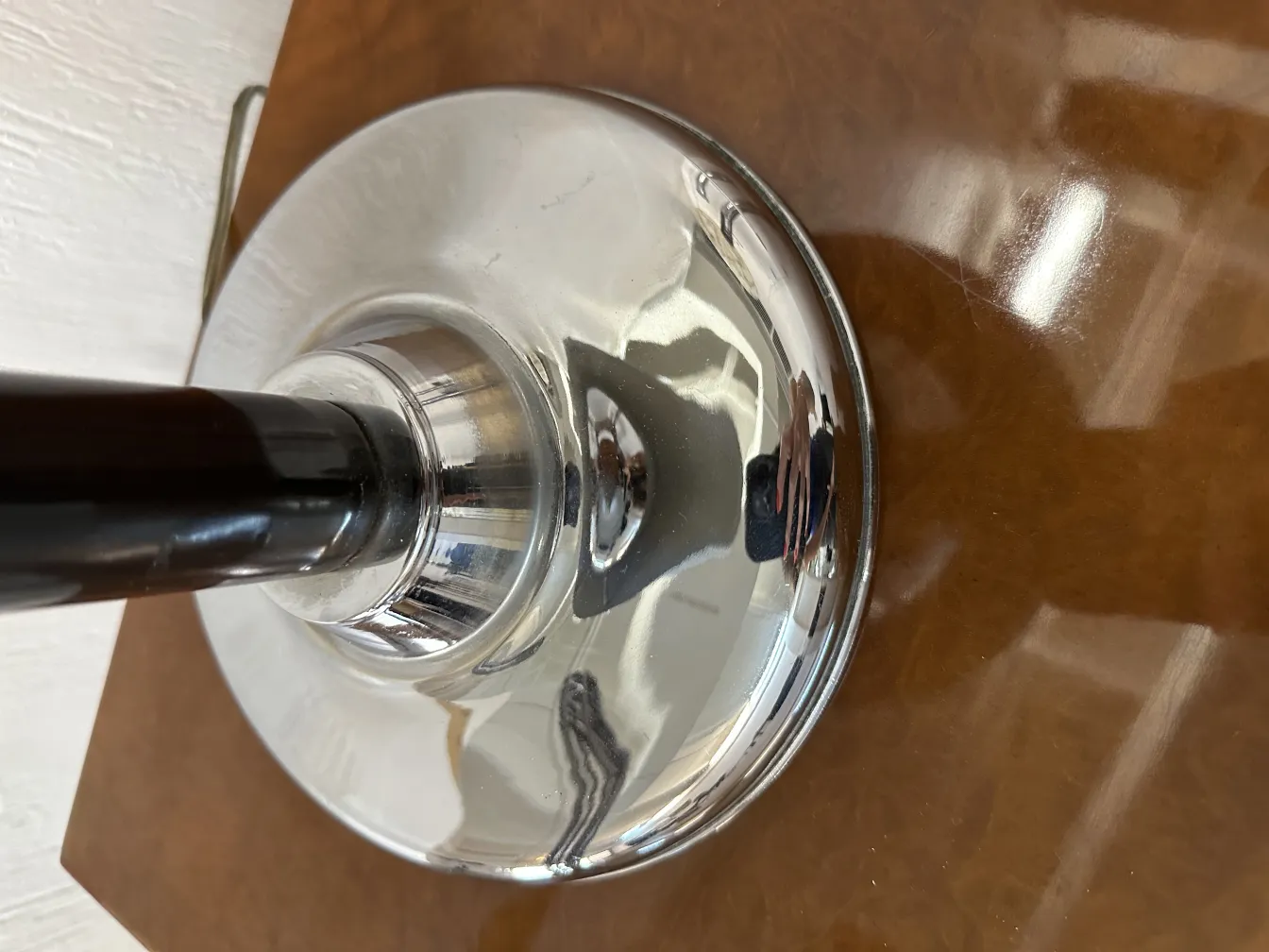 antike Tischlampe mit glänzendem Sockel und elegantem Design auf einem braunen Hintergrund