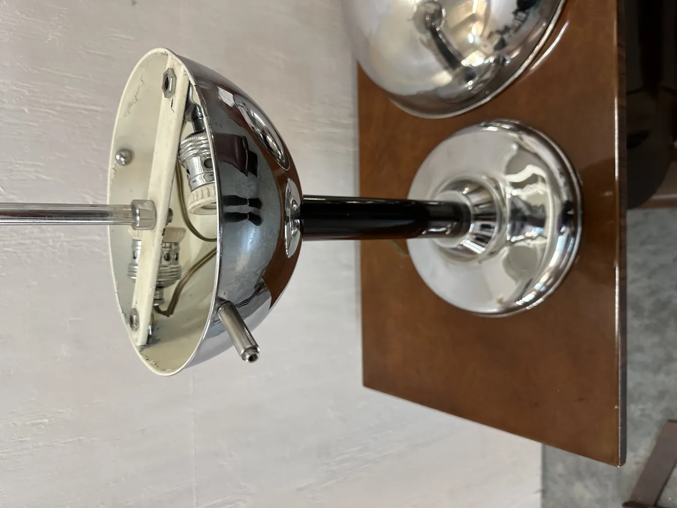 Lampada da tavolo antica con base lucida in un ambiente decorativo.