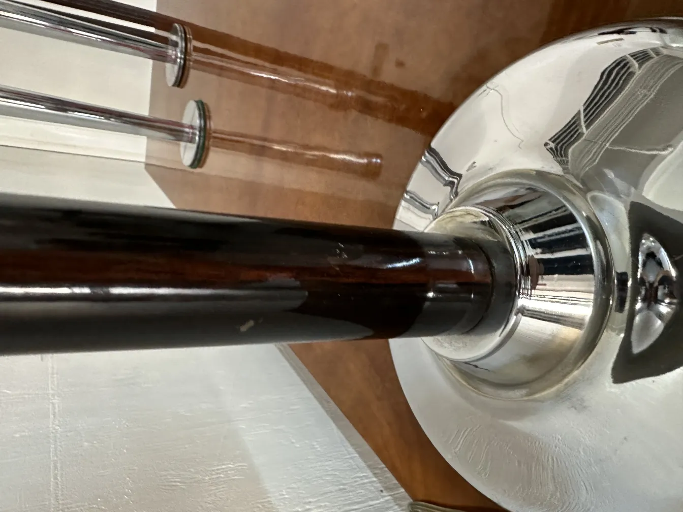 Details einer antiken Tischlampe mit glänzendem Fuß, neutraler Hintergrund