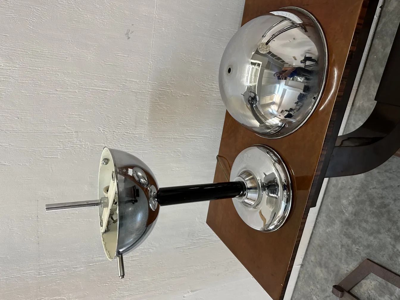 lampada da tavolo antica con finitura lucida e design elegante, posizionata su una superficie in legno con colori argentati