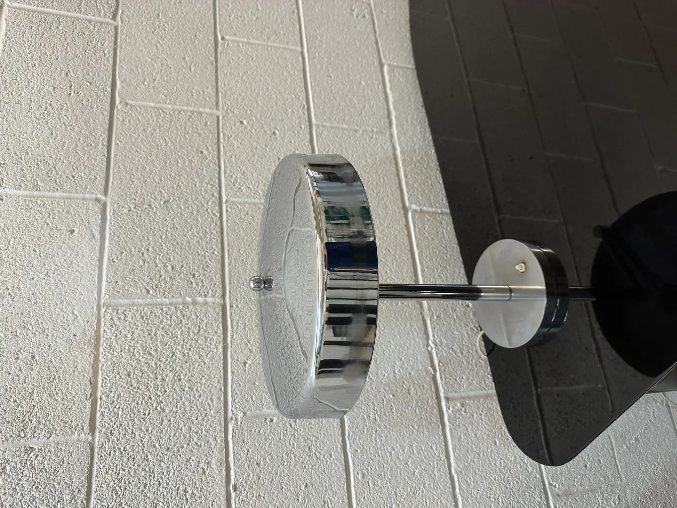 Antike Tischlampe mit glänzender Oberfläche in einer neutralen Umgebung.