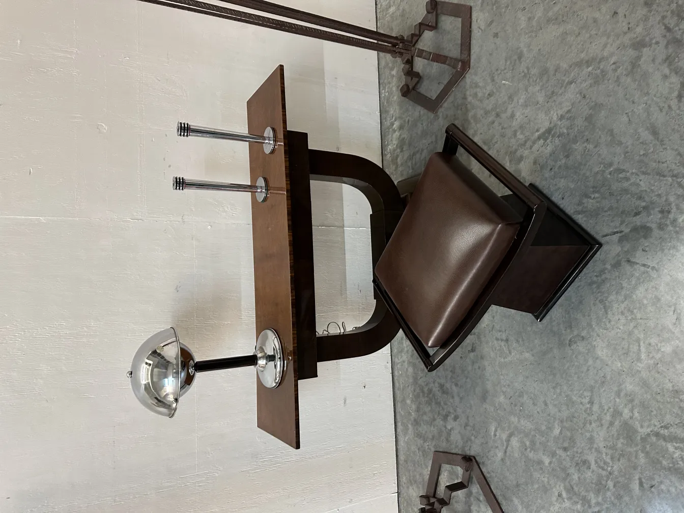 antik tischlampe mit glänzender oberfläche und stromlinienförmigem design, neben einem stuhl und einem schreibtisch