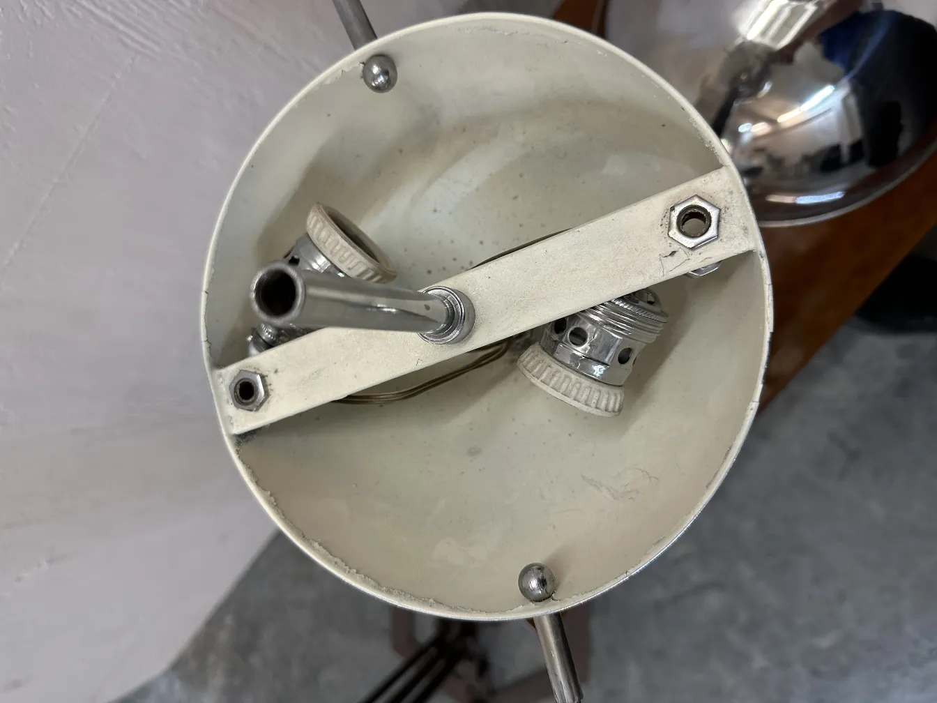 Vue de dessus d'une lampe de bureau antique avec intérieur blanc, mettant l'accent sur la douille et les détails métalliques.