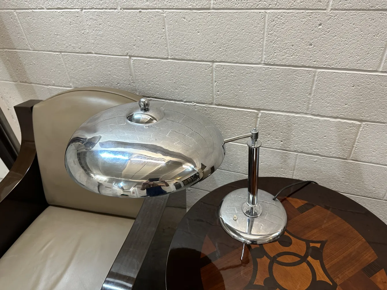 Antique table lamp with a minimalist design. Metallic reflections and an oval shape in a modern setting.