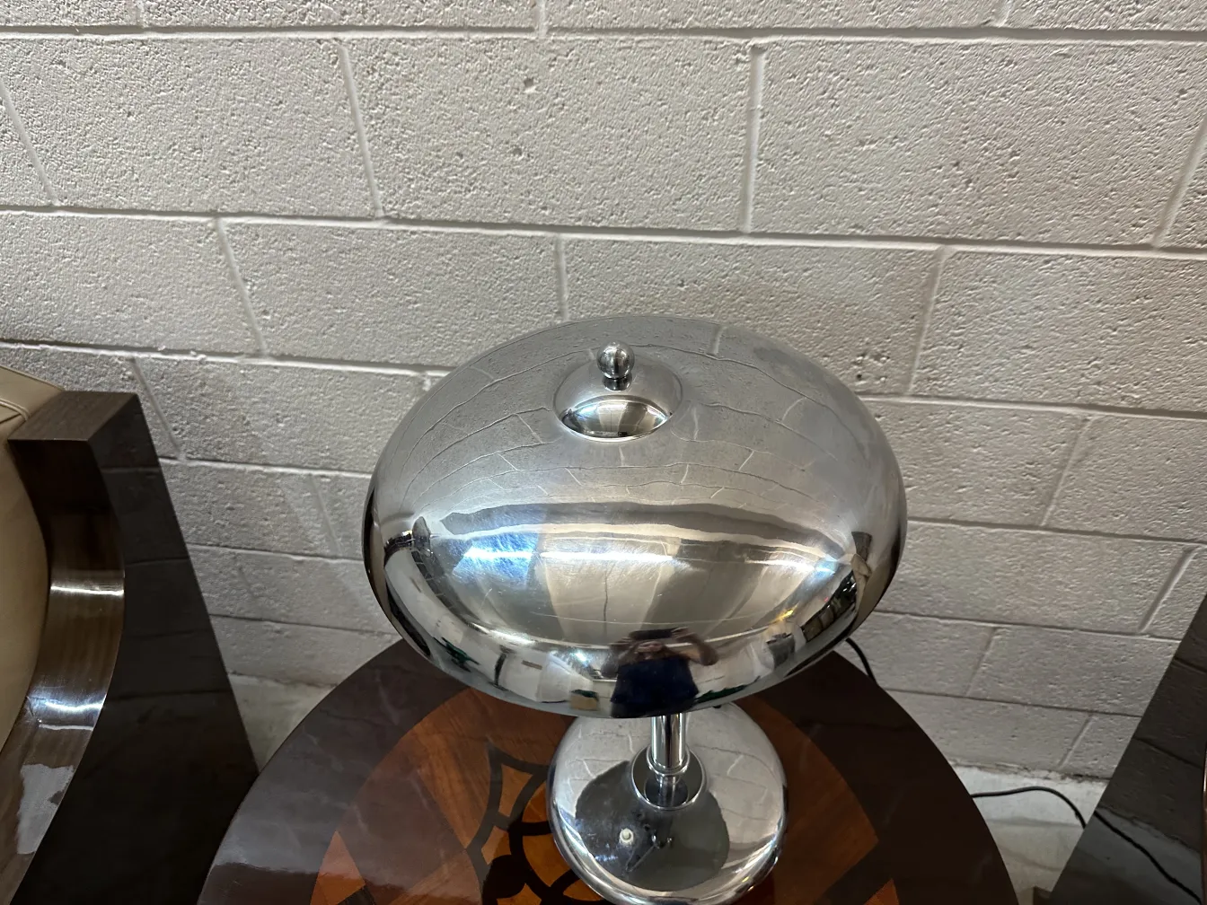 Luminária de mesa antiga com base esférica em um ambiente moderno. Brilha com um acabamento luminoso.