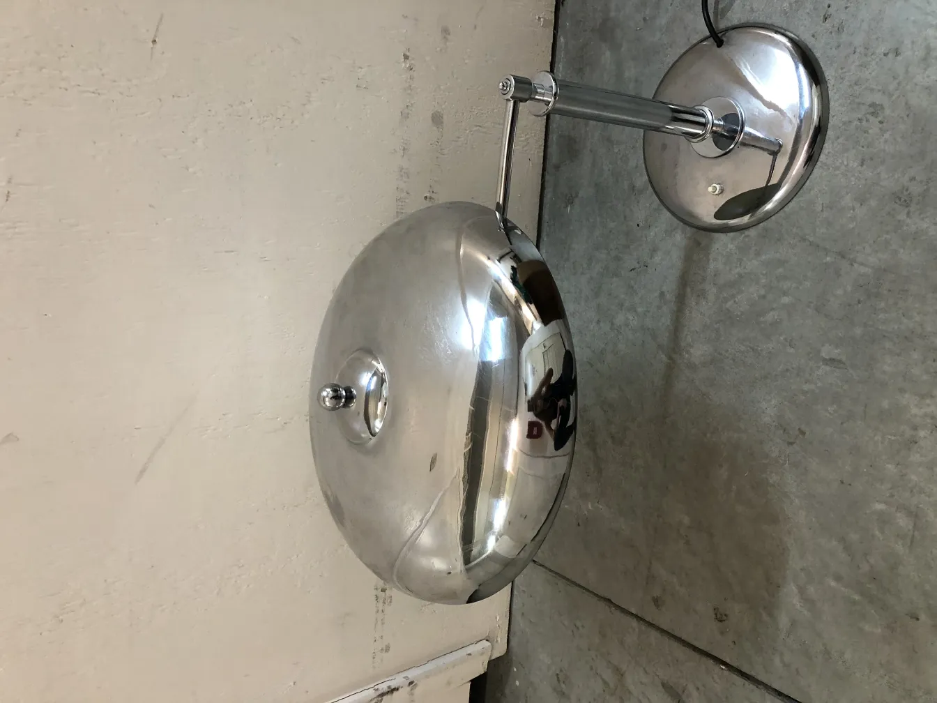 Antike Tischlampe mit rundem, glänzendem Design, wandmontiert, in einem eleganten Ambiente.