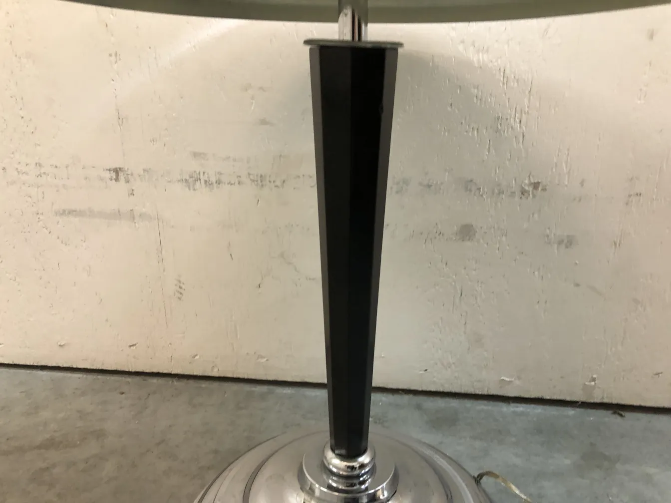 Luminária de mesa antiga com base preta e detalhes brilhantes no suporte.