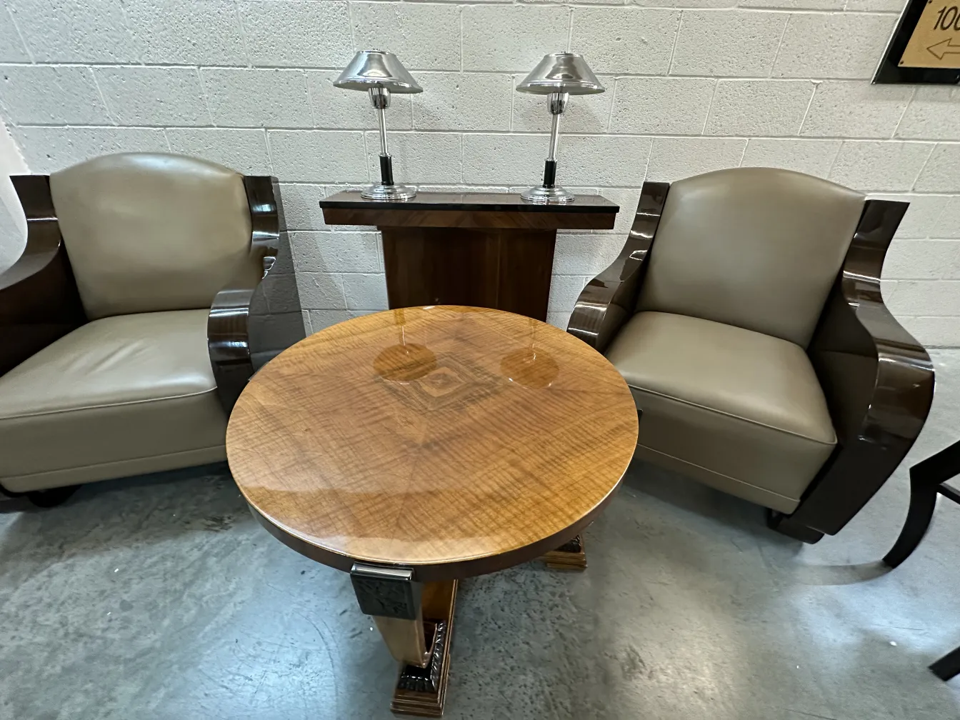 Antiga luminária de mesa com design elegante, acompanhada de poltronas e uma mesa.