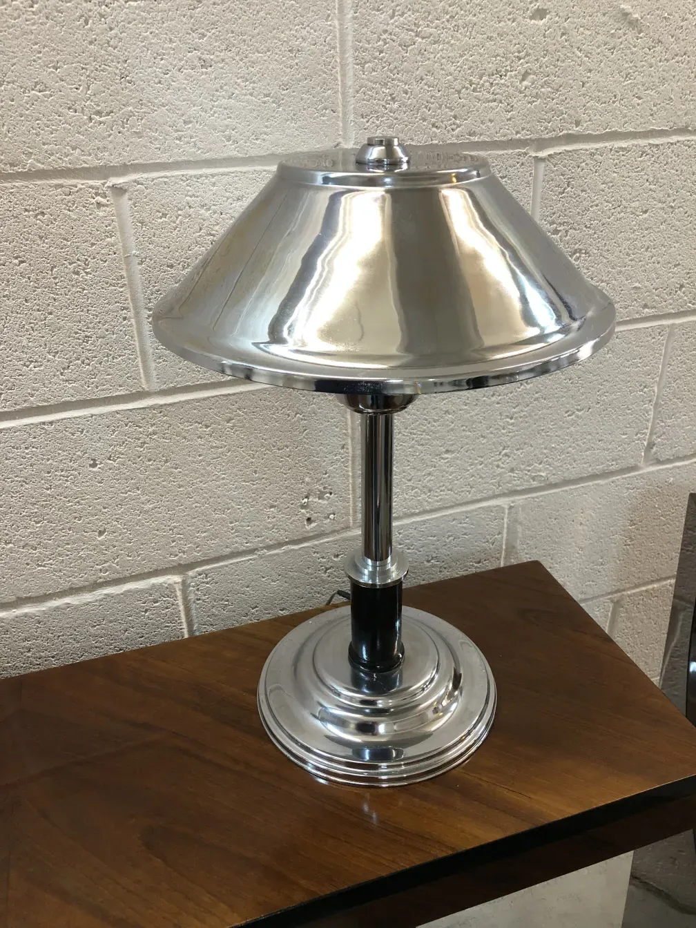 luminária de mesa antiga com acabamento brilhante, ambiente neutro