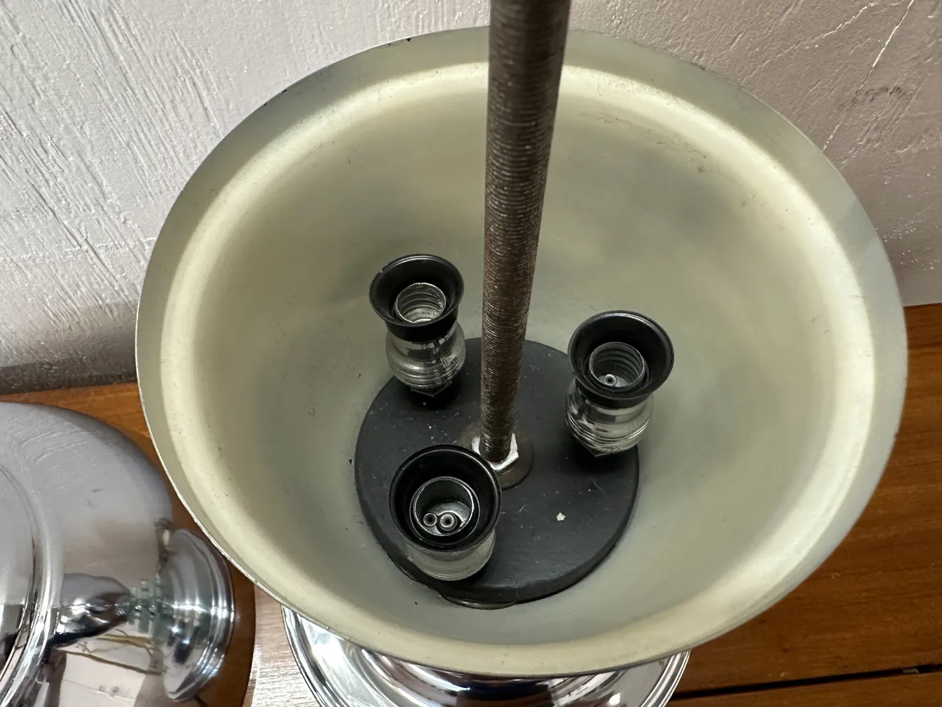 Vue du dessus d'une lampe de bureau ancienne avec plusieurs bases, dans un environnement confortable.