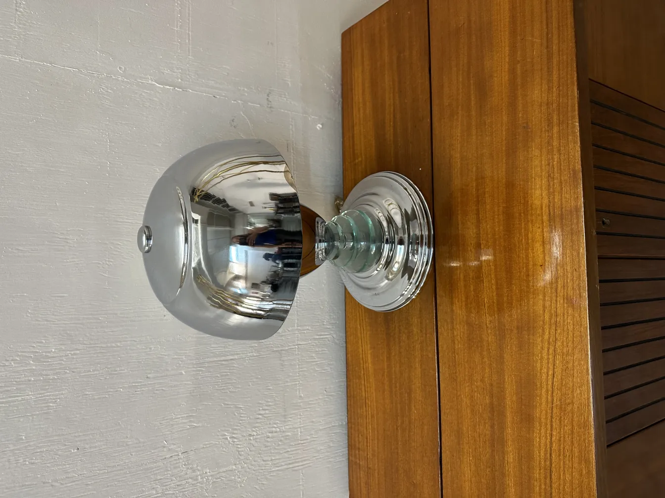 Lampada da tavolo antica con finitura lucida su una superficie in legno.