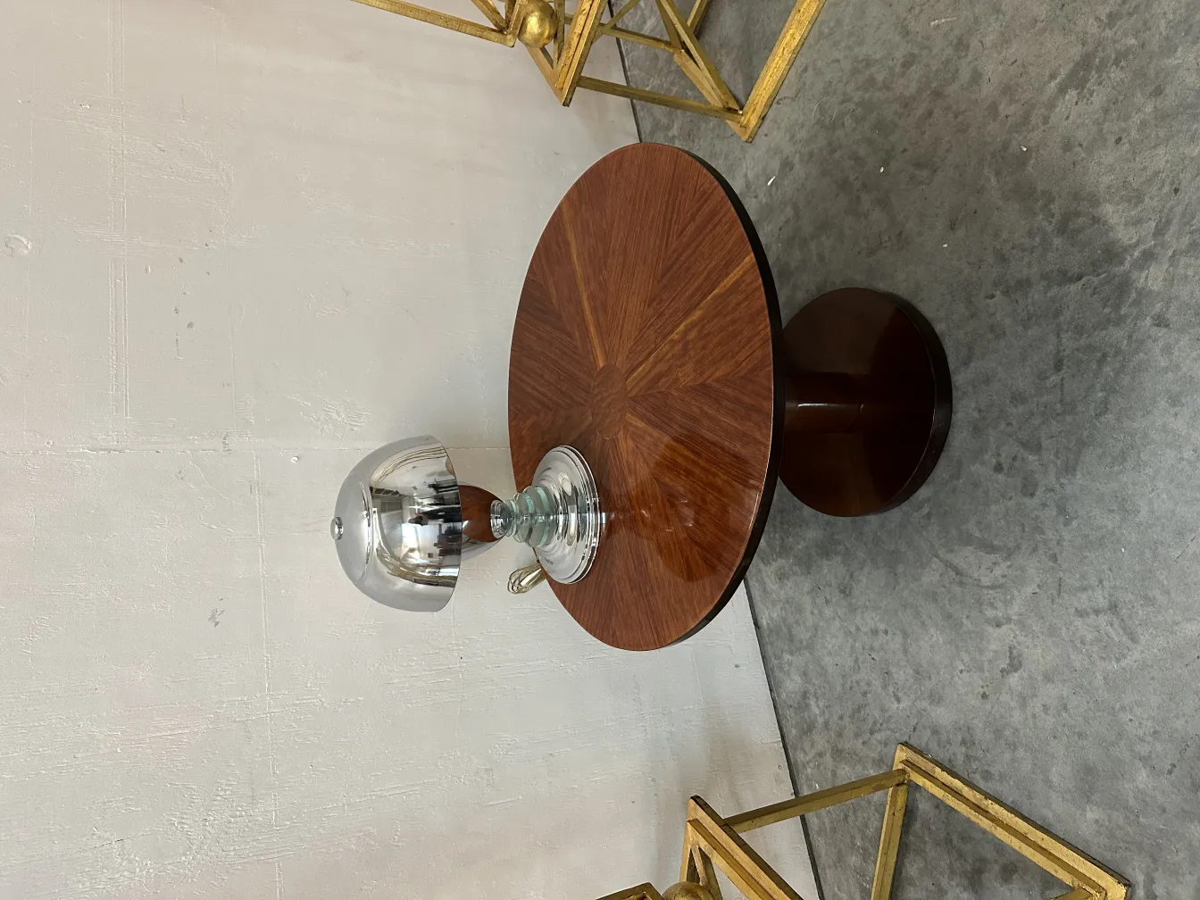 antike tischlampe mit eleganter gekrümmter basis, umgeben von goldenen möbeln und einem runden tisch