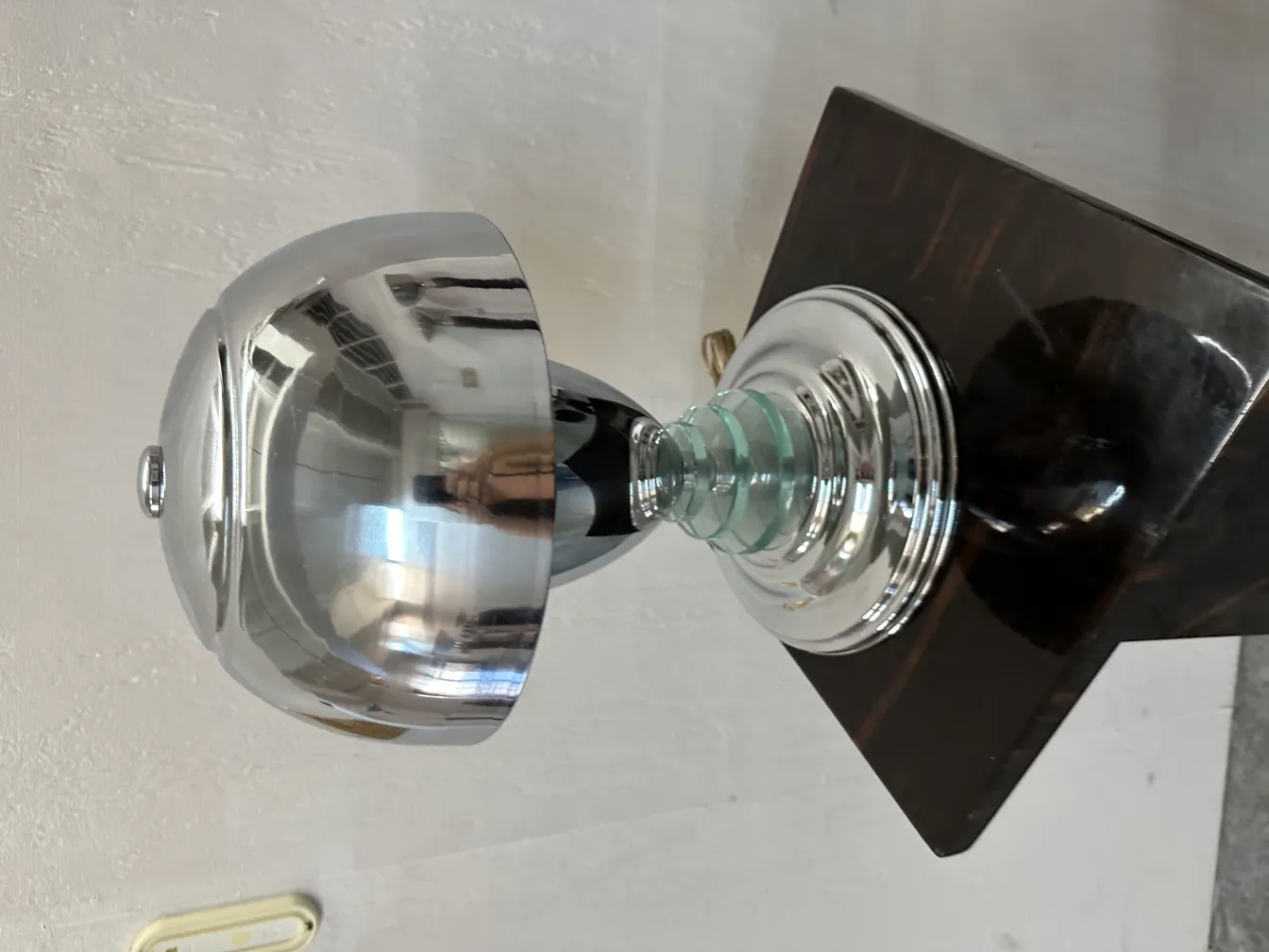 Luminária de mesa antiga com base brilhante e design elegante em um ambiente aconchegante.