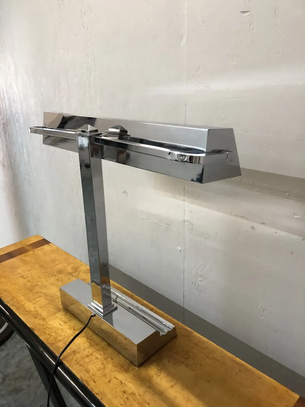 lampada da tavolo antica con base lucida su un tavolo in legno chiaro