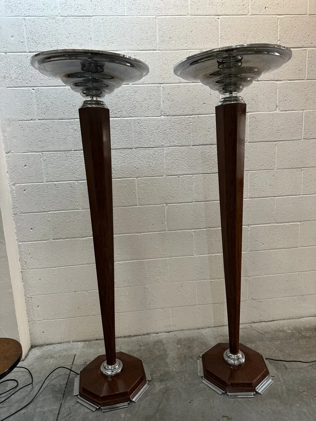 2 lampadaires antiques avec bases décoratives sur fond neutre