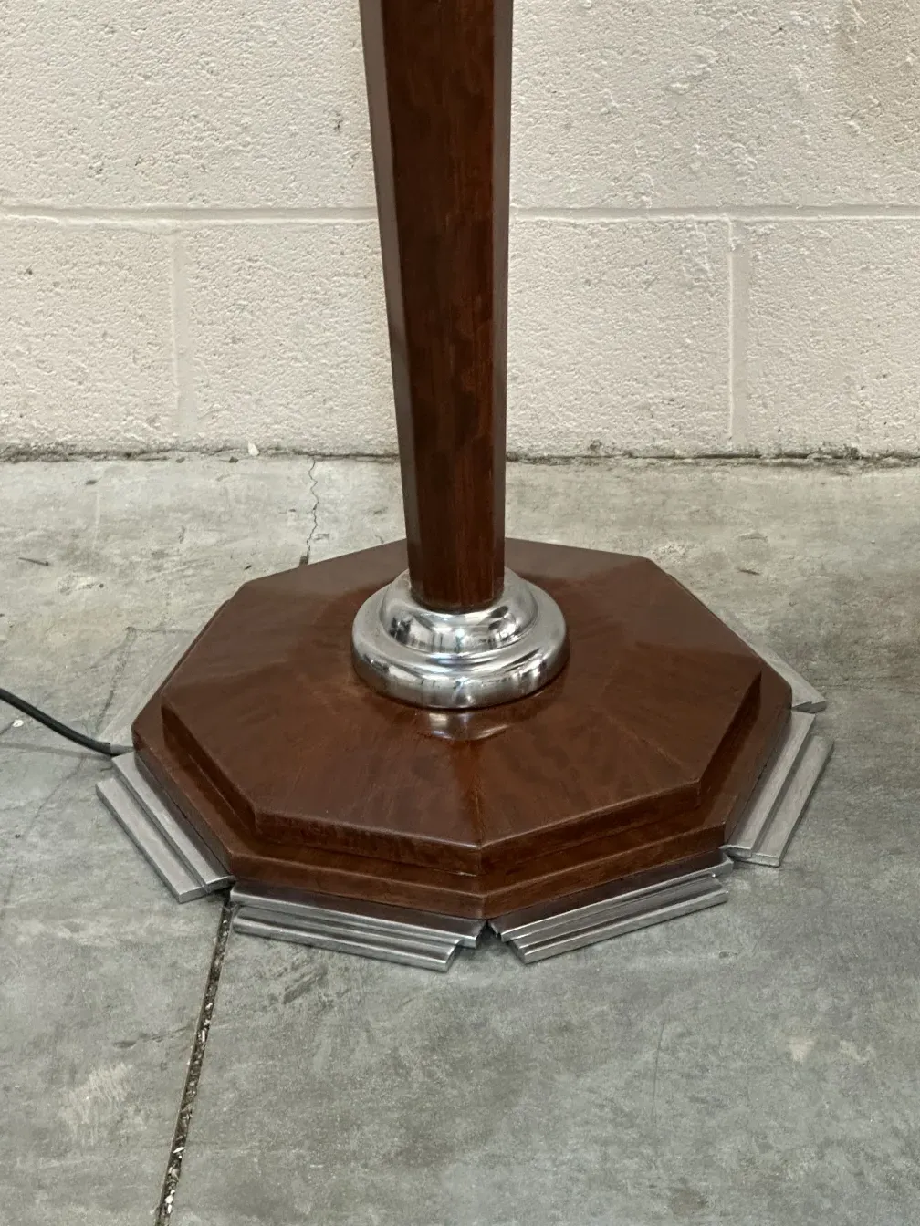 古董落地灯的细节视图，带八角底座，置于中性环境中。