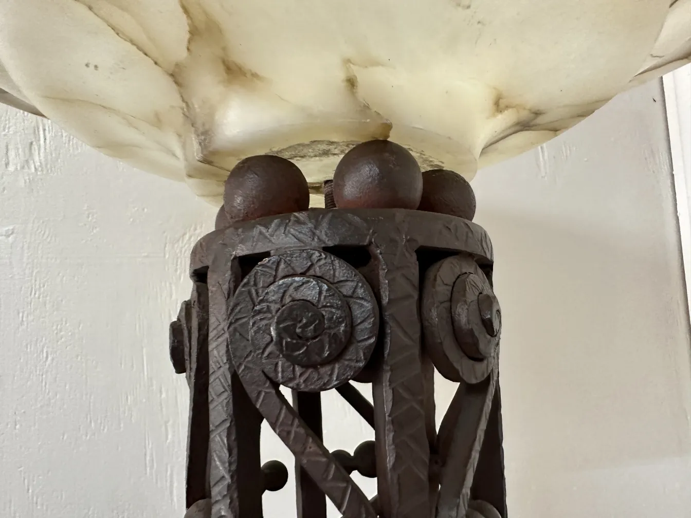 Vista cercana de 2 lámparas de pie antiguas con base decorativa, en un ambiente acogedor.