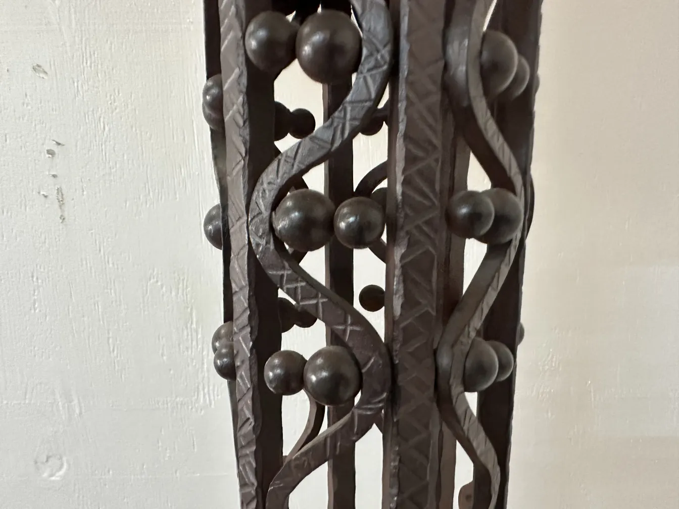 Side view of two antique floor lamps, featuring intricate structure and decorative spheres in the design.