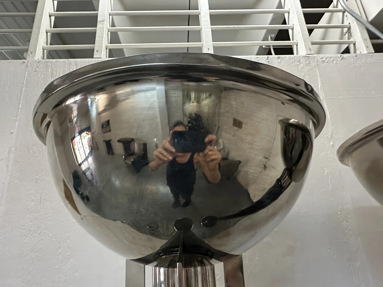 Visão de duas lâmpadas de piso antigas em um ambiente iluminado, refletindo o ambiente.