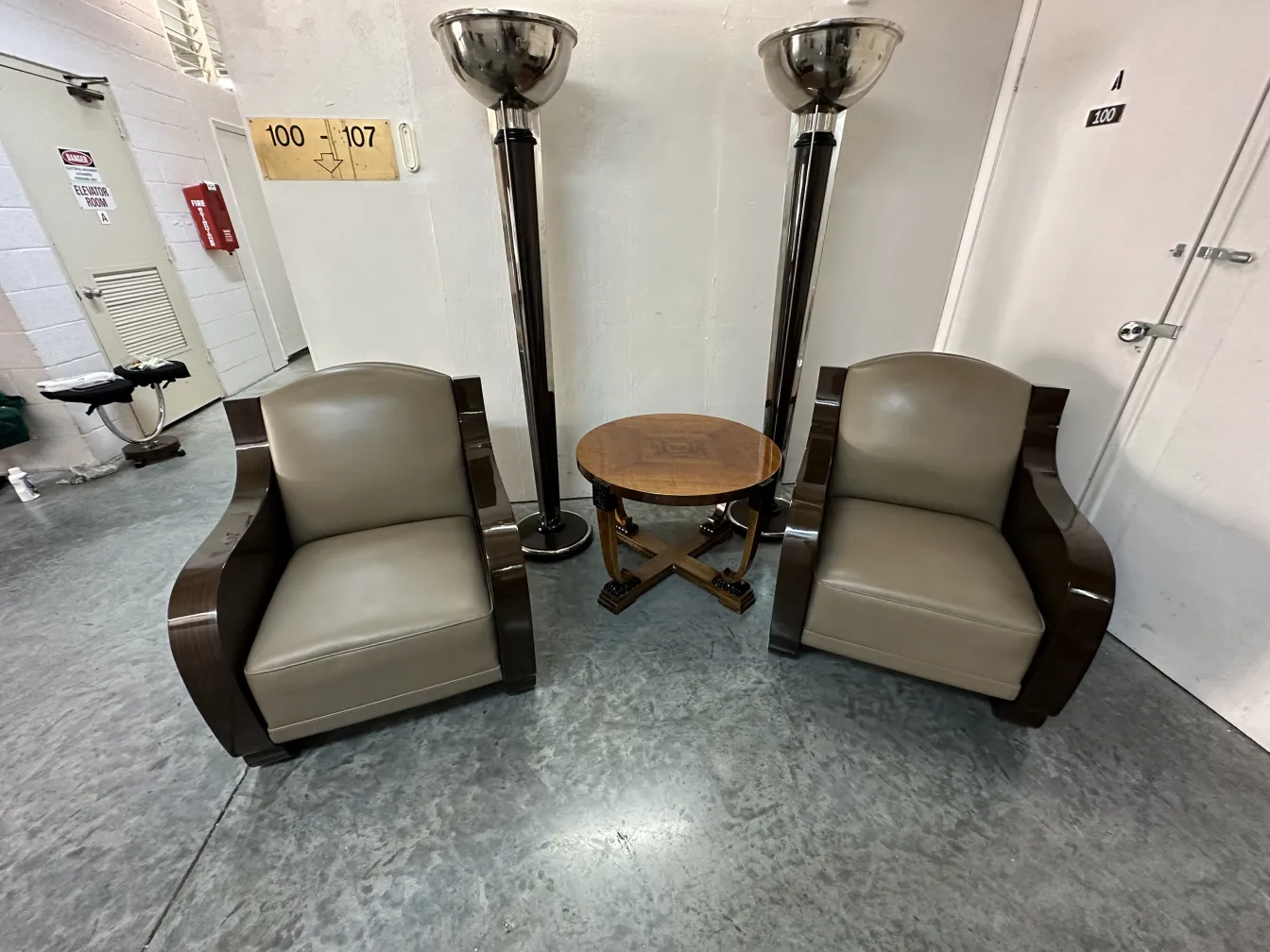 Deux lampadaires anciens à côté de fauteuils dans un cadre confortable.