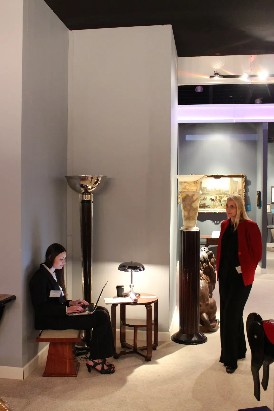 Two antique floor lamps on display with decorative base in an elegant setting.