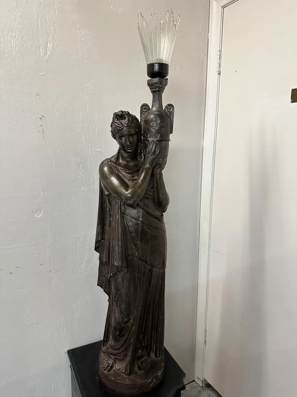 Antica lampada da terra con figura in un ambiente elegante