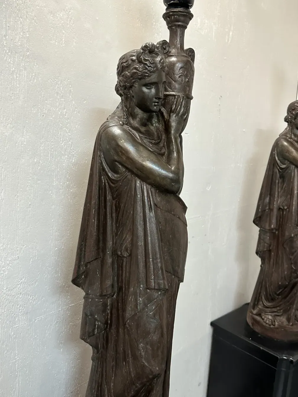 Antike Stehlampe mit männlicher Figur und dekorativem Sockel, geeignet für klassische Räume.