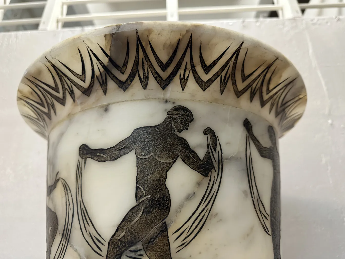 2 antique floor lamps adorned with human figures in a bright setting.